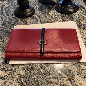 Red leather clutch with black leather detail.